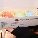 Someone holding the Holiday Christmas Bath Bomb Set in front of a colorful background, showing the inside.