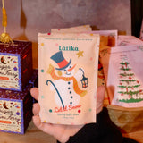 Someone holding the Snow Bath Soak in front of other bath products.