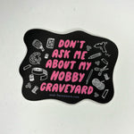 The Don't Ask Me About My Hobby Graveyard - Vinyl Sticker on a gray background.