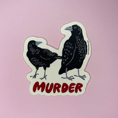 The Murder Crow Vinyl Sticker on a pink background.