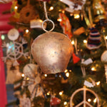 Someone holding the large Yuletide Protection Bell in front of a Christmas tree.