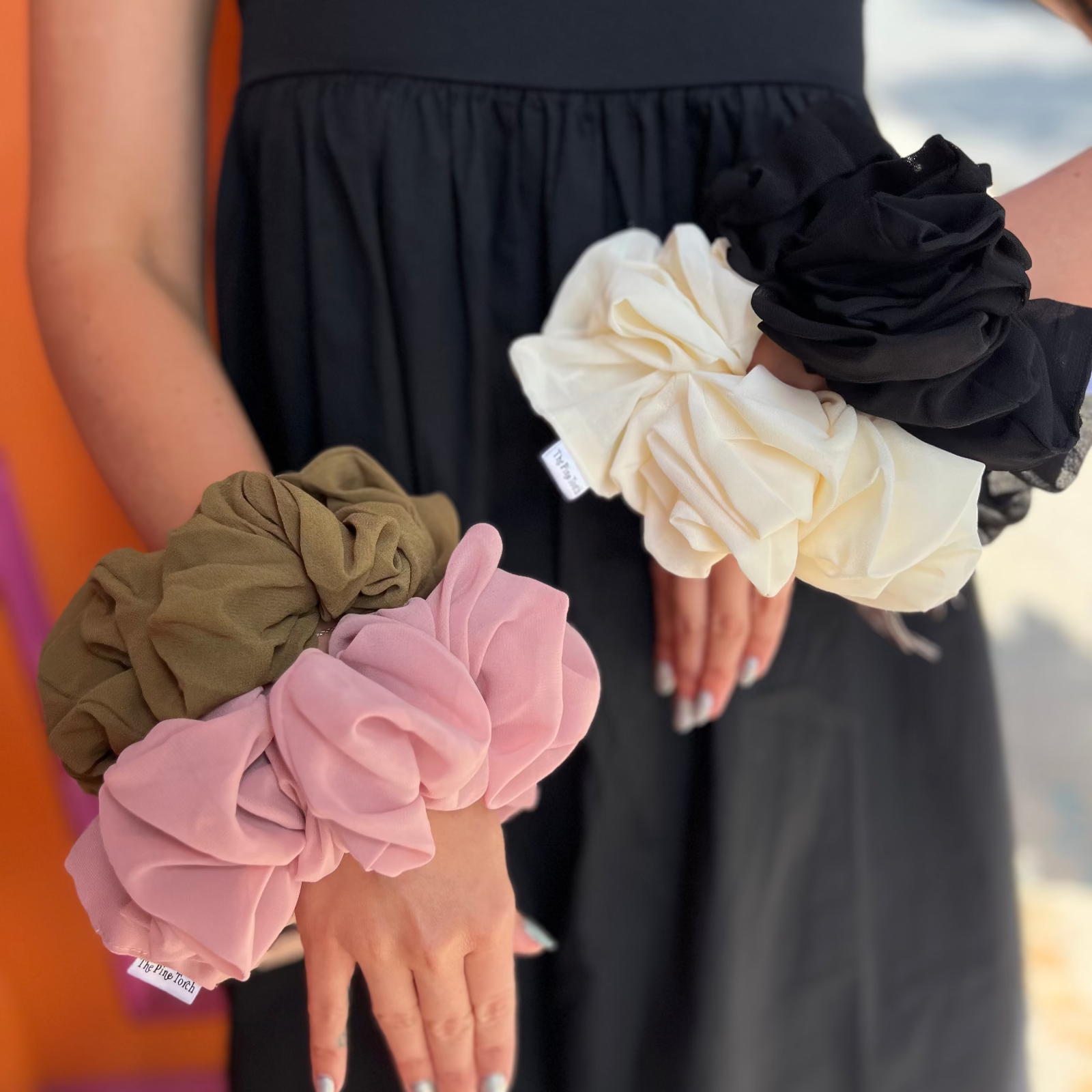 Someone wearing all four XL Jumbo Chiffon Scrunchies on their wrists.