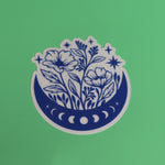 The Flower Moon Phase Sticker on a green background.