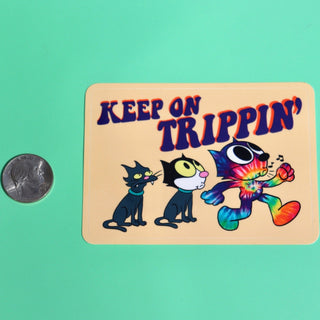 The Keep On Trippin 4 Inch Sticker next to a quarter on a green background.