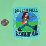 The Ramblin' Man 3 Inch Sticker next to a quarter on a green background.