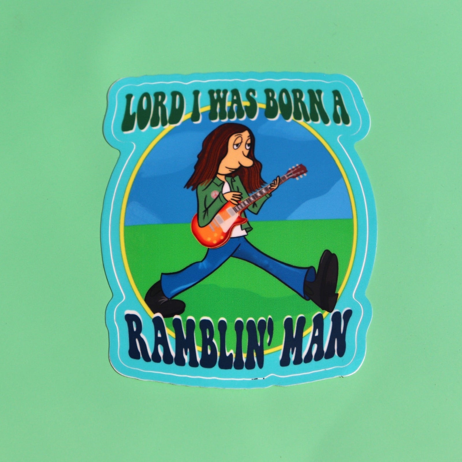 The Ramblin' Man 3 Inch Sticker on a green background.