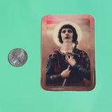 The Joan of Arc 3 Inch Sticker next to a quarter on a green background.