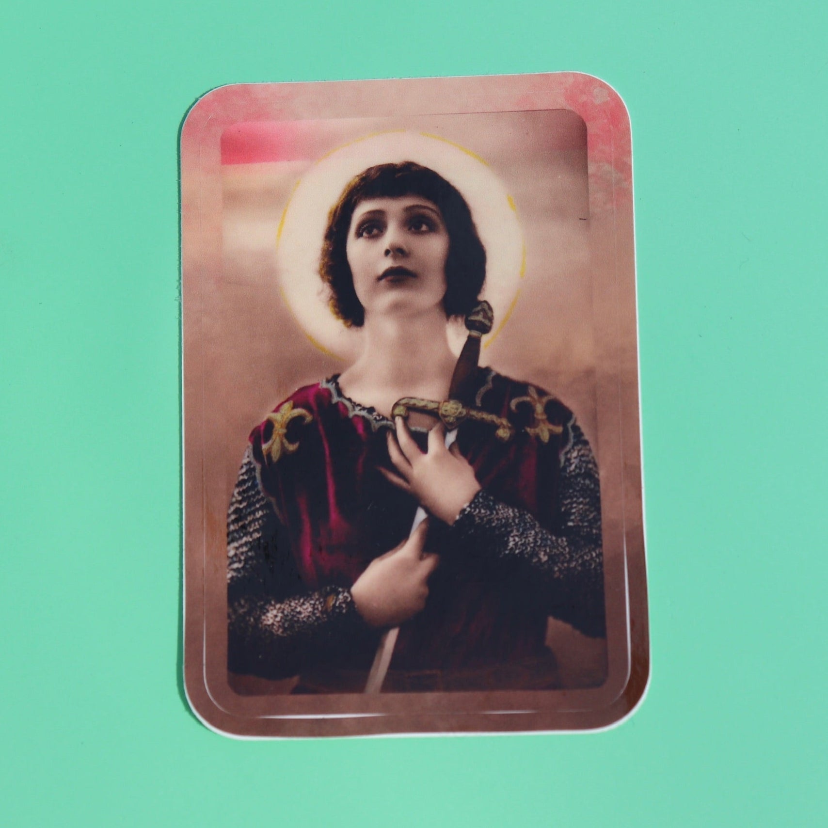 The Joan of Arc 3 Inch Sticker on a green background.