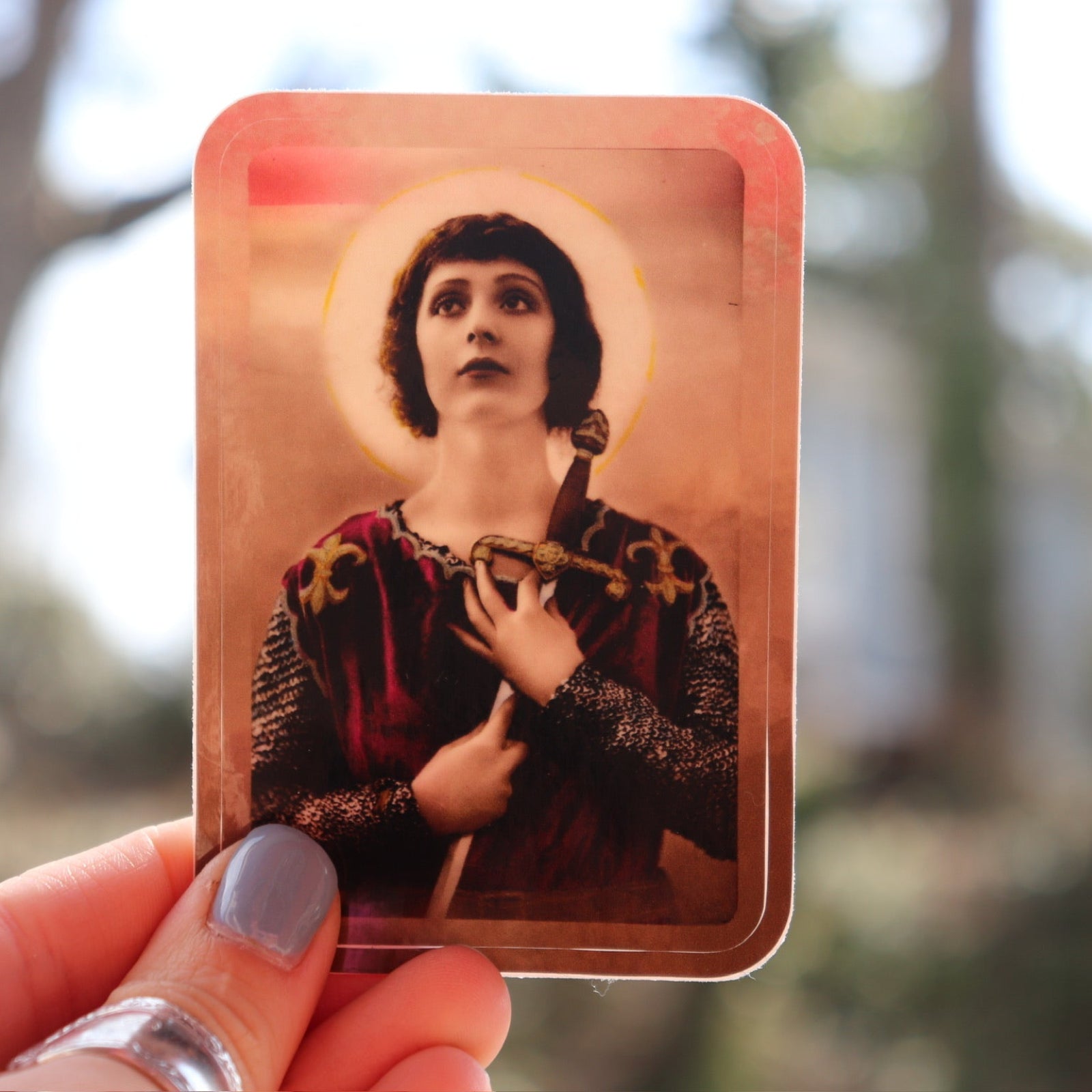 Someone holding the Joan of Arc 3 Inch Sticker.