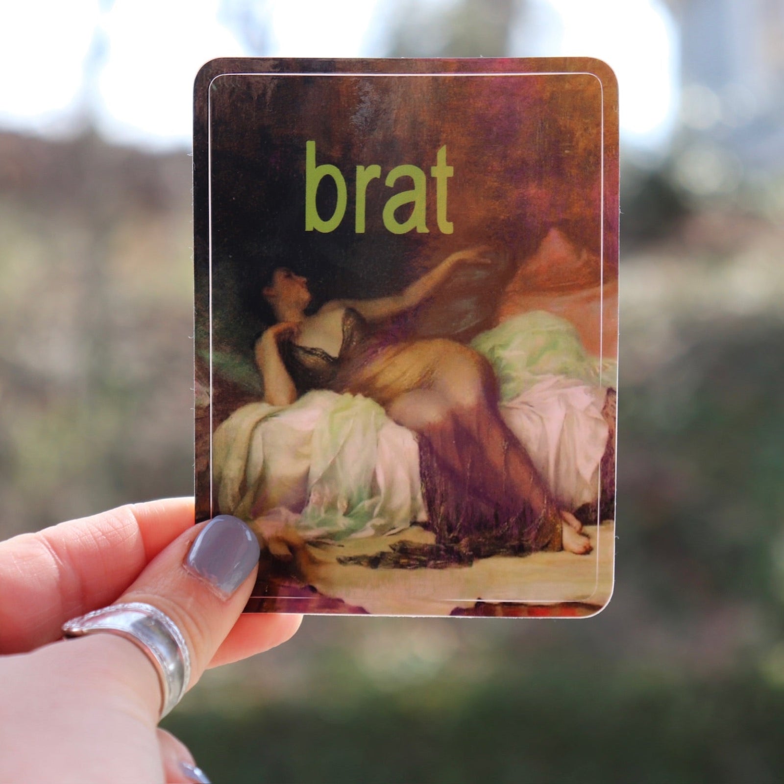 Someone holding the Brat 3 Inch Vinyl Sticker.