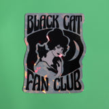 The Black Cat Fan Club 3 Inch Holographic Sticker on a green background.
