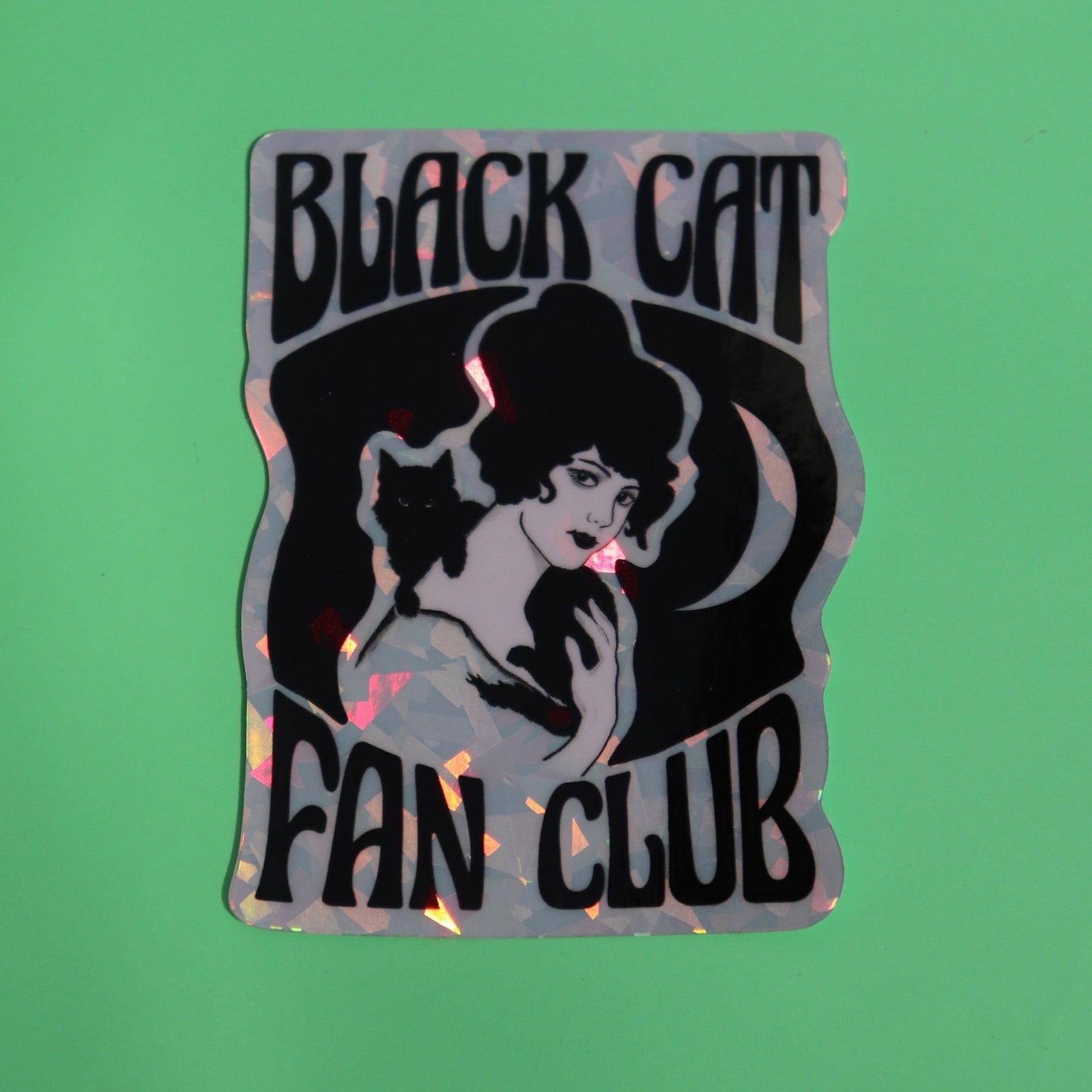 The Black Cat Fan Club 3 Inch Holographic Sticker on a green background.