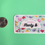 The Menty B Mental Health Anxiety Sticker next to a quarter on a green background.
