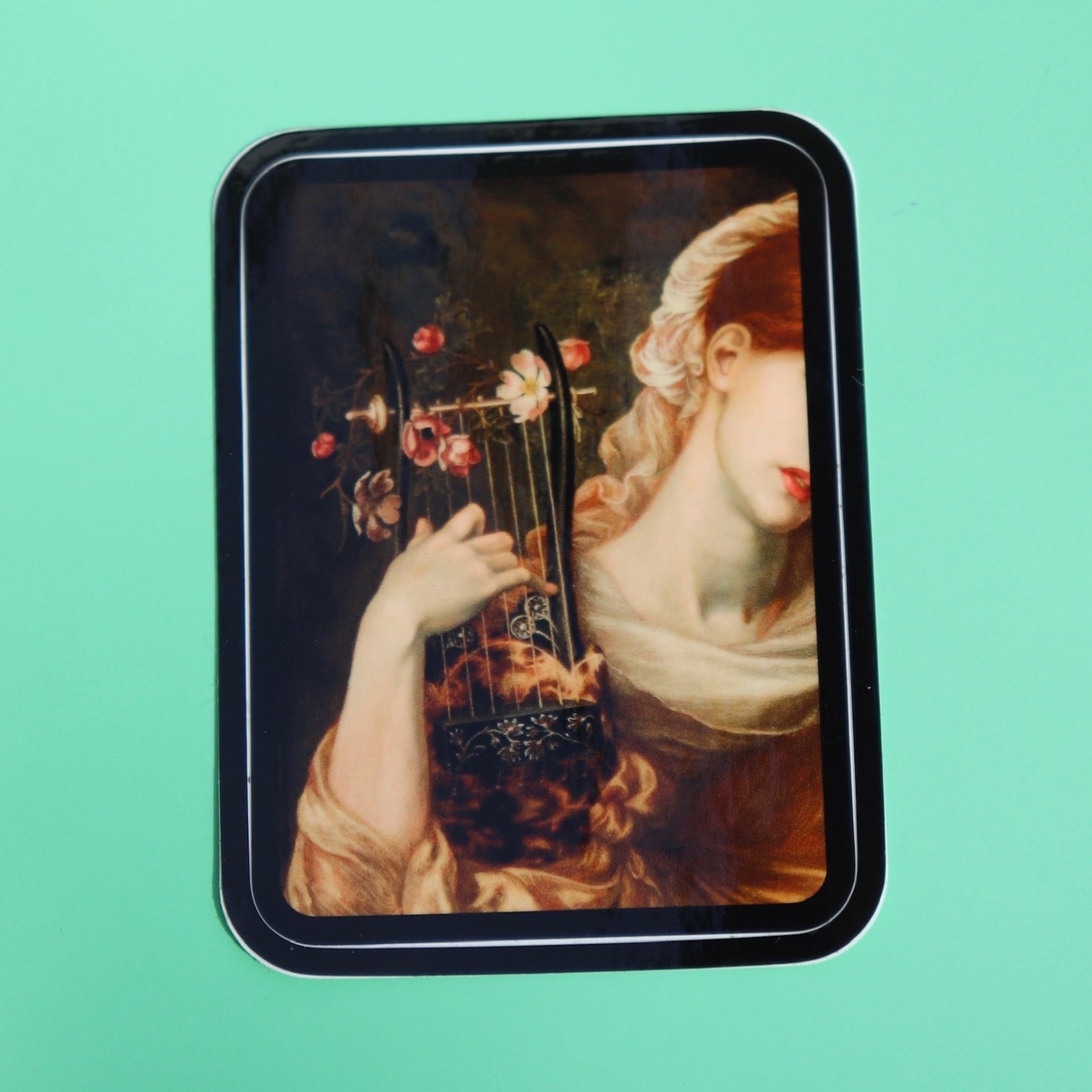 The Lyre Player Pre-Raphaelite 3 Inch Vinyl Sticker on a green background.