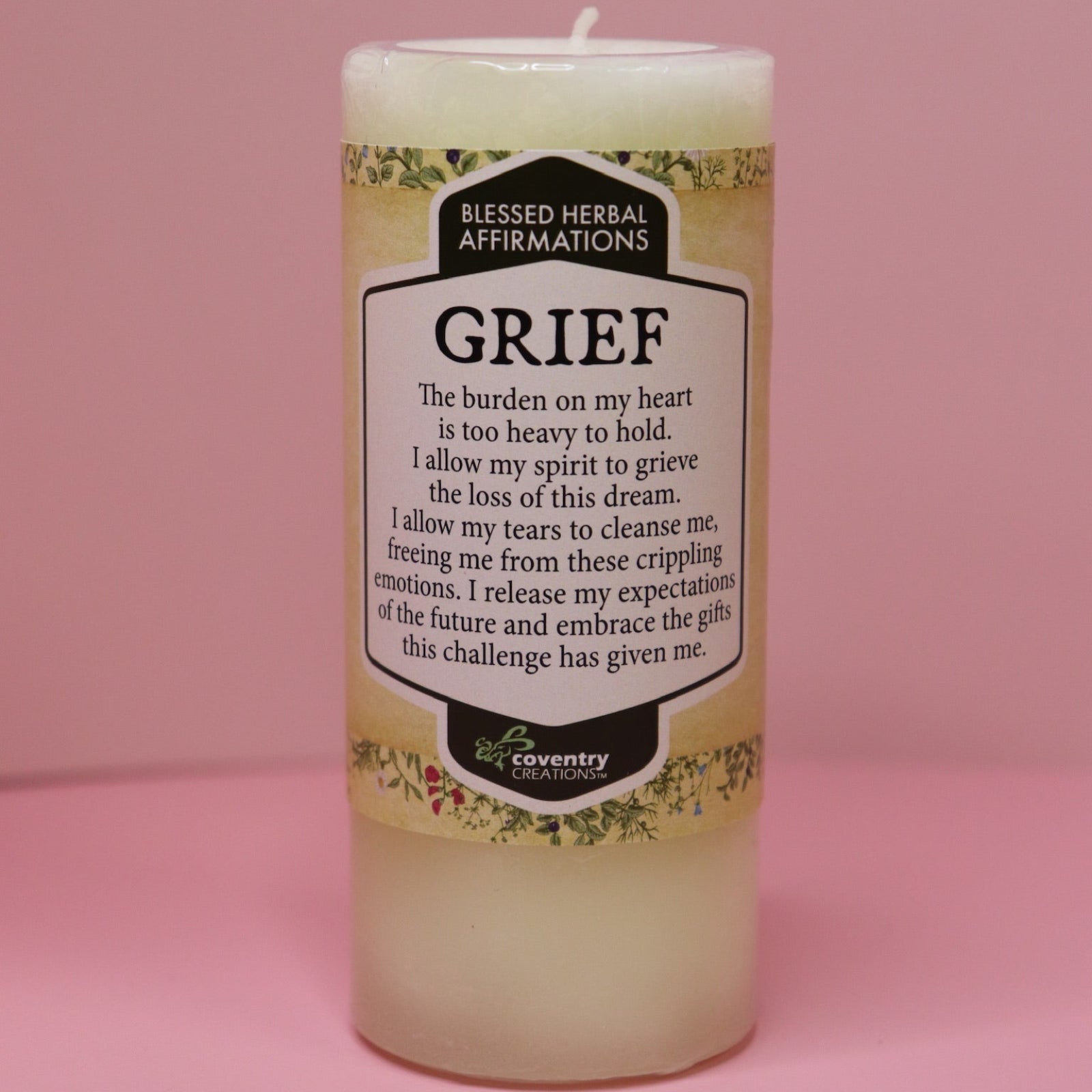 The Affirmation Grief Candle - Pillar Candle with Cypress Blend on a pink background.