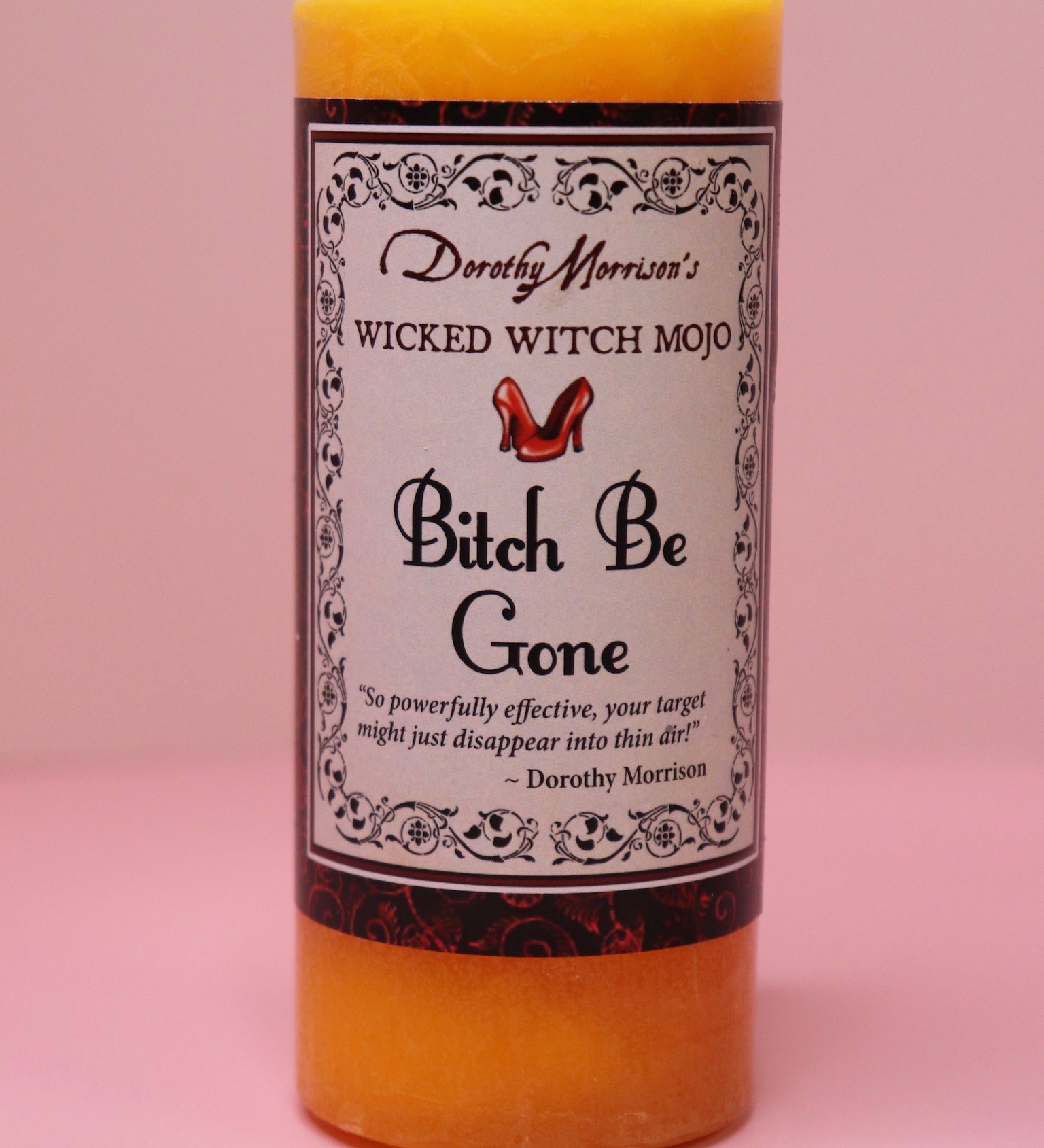 The Wicked Witch Mojo Bitch Be Gone- Scented Pillar Candle on a pink background.