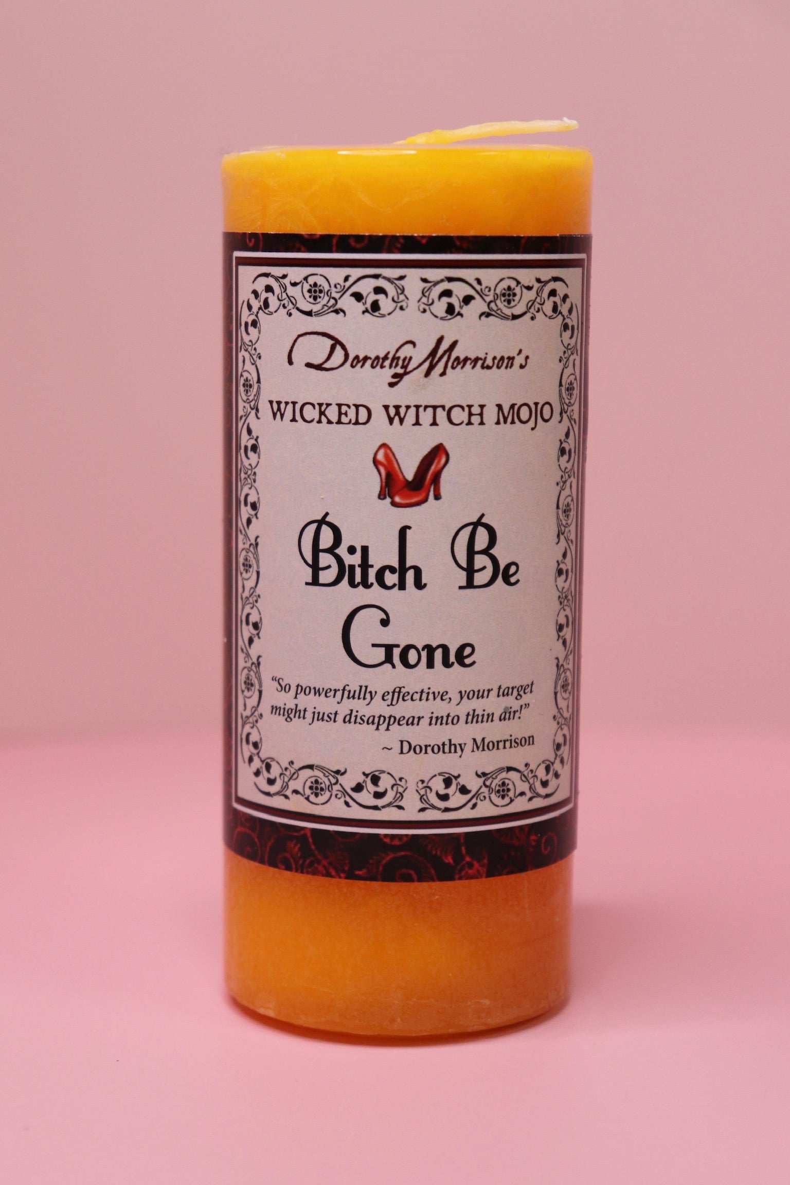 The Wicked Witch Mojo Bitch Be Gone- Scented Pillar Candle on a pink background.