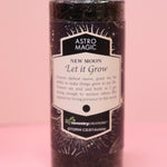 The Astro Magic New Moon - Let it Grow Pillar Candle on a pink background.