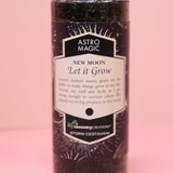 The Astro Magic New Moon - Let it Grow Pillar Candle on a pink background.