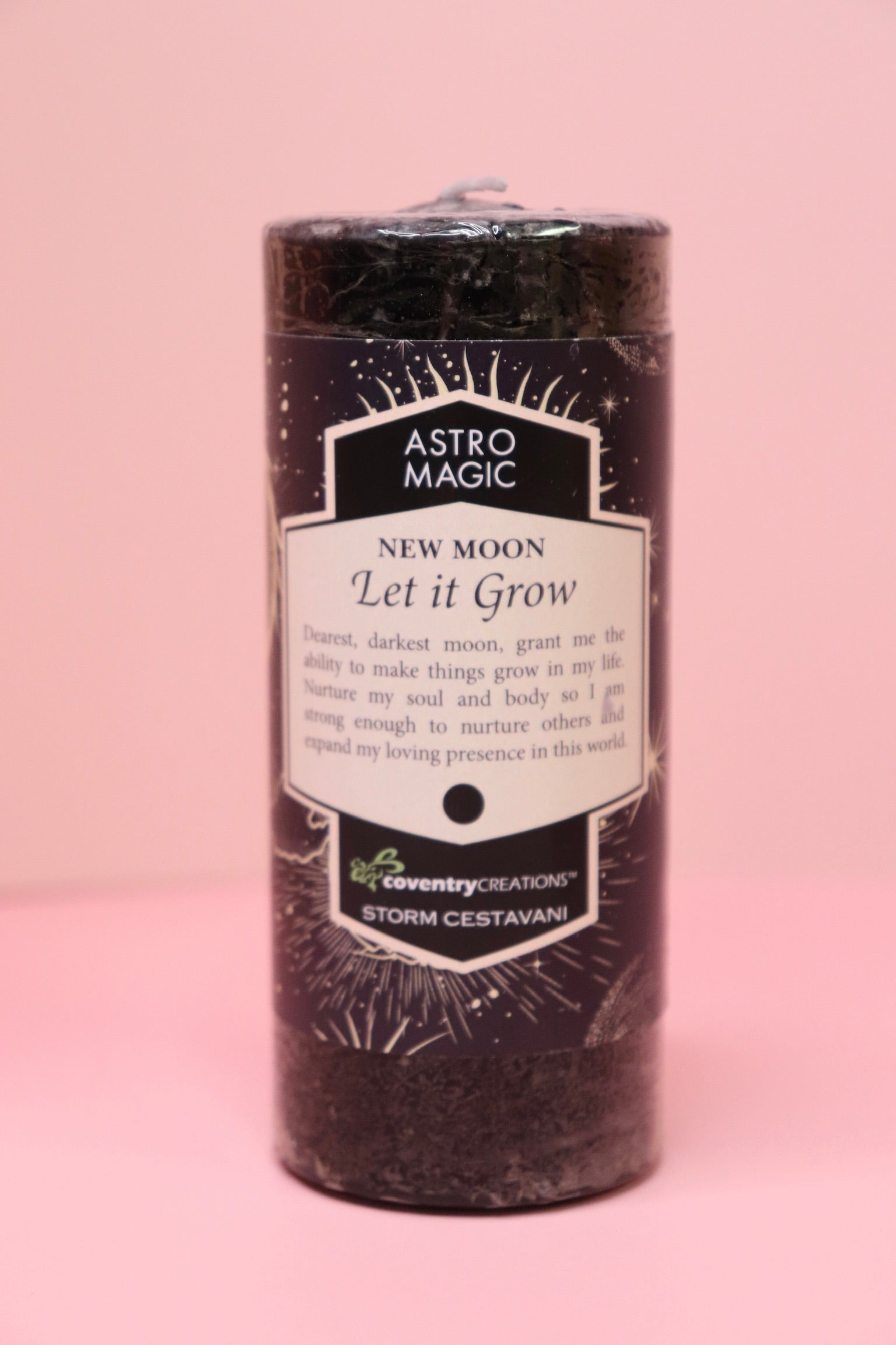 The Astro Magic New Moon - Let it Grow Pillar Candle on a pink background.