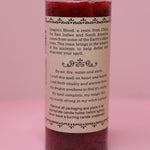 The back of the Witch's Brew Dragon's Blood - Scented Pillar Candle on a pink backgorund.