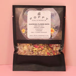 The Soothing Flower Bath Salt Packet on a pink background.