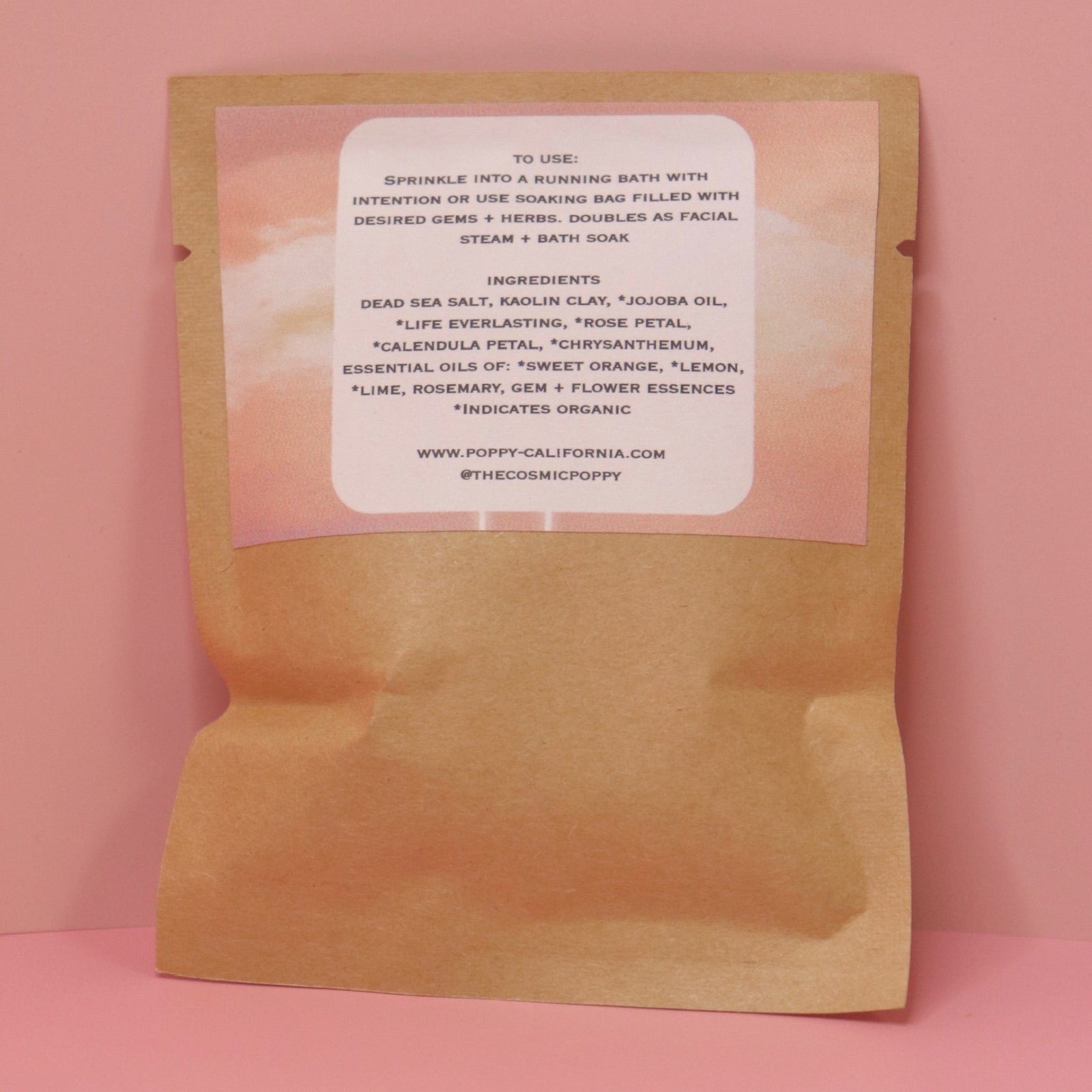 The back of the Uplifting Flower Bath Salt Packet on a pink background.