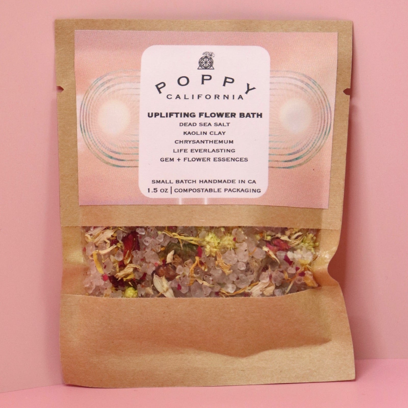 The Uplifting Flower Bath Salt Packet on a pink background.