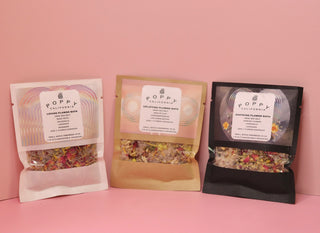All three of the Poppy California Bath Salt Packets on a pink background.