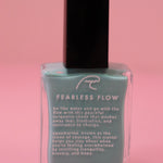 The Fearless Flow Nail Polish with Micronized Aquamarine on a pink background.
