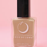 The Gaia Grounding Nail Polish with Micronized Hematite on a pink background.