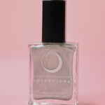 The Aquarius Zodiac Nail Polish with Micronized Amethyst on a pink background.