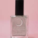 The Aquarius Zodiac Nail Polish with Micronized Amethyst on a pink background.