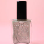 The Aquarius Zodiac Nail Polish with Micronized Amethyst on a pink background.