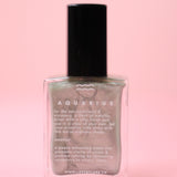 The Aquarius Zodiac Nail Polish with Micronized Amethyst on a pink background.