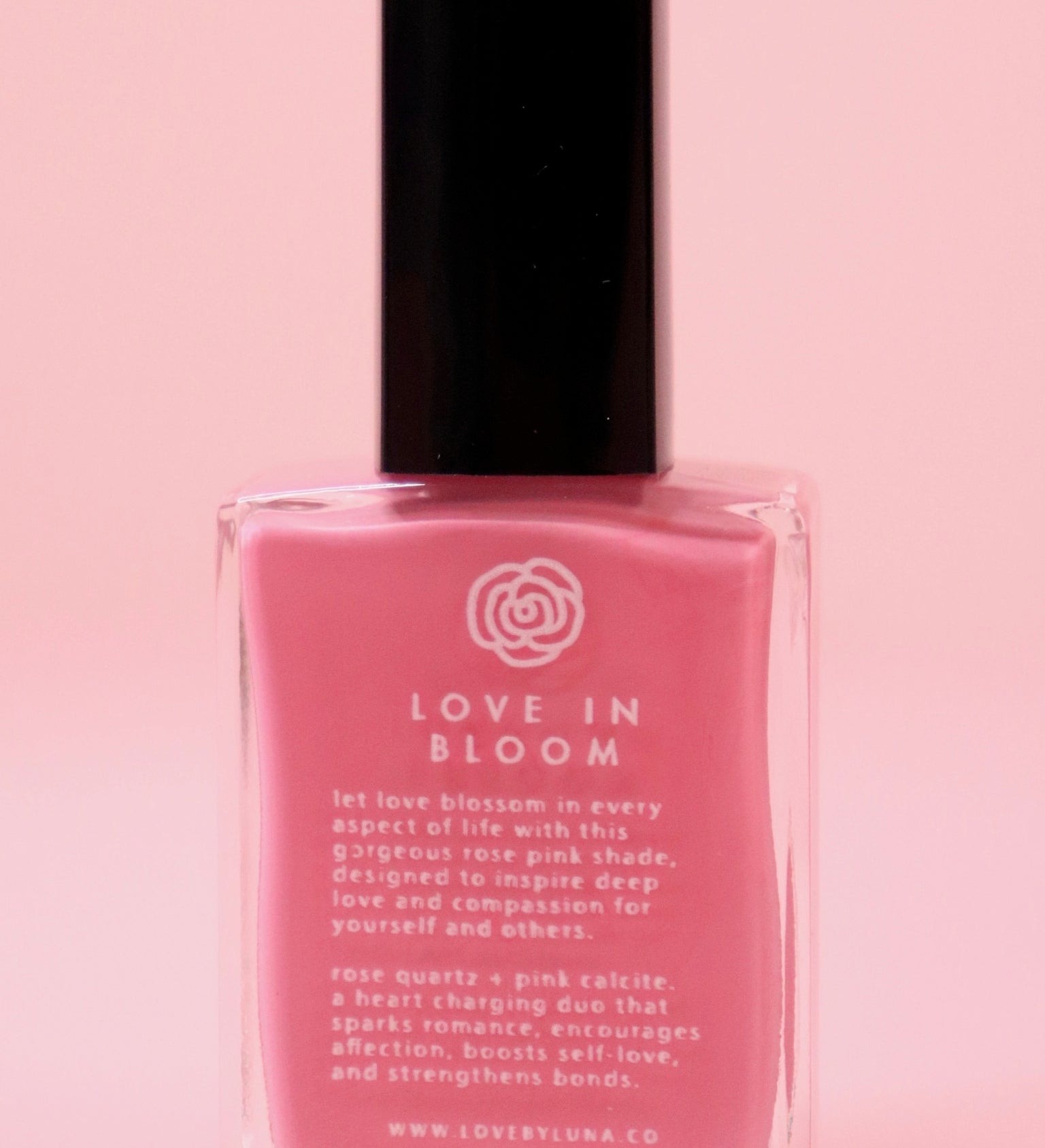 The Love in Bloom Nail Polish with Micronized Rose Quartz & Pink Calcite on a pink background.