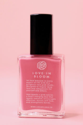The Love in Bloom Nail Polish with Micronized Rose Quartz & Pink Calcite on a pink background.
