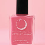 The Love in Bloom Nail Polish with Micronized Rose Quartz & Pink Calcite on a pink background.