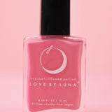 The Love in Bloom Nail Polish with Micronized Rose Quartz & Pink Calcite on a pink background.