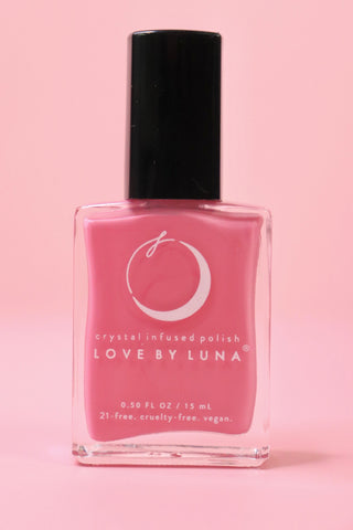 The Love in Bloom Nail Polish with Micronized Rose Quartz & Pink Calcite on a pink background.