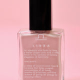The Libra Zodiac Nail Polish with Micronized Rose Quartz in a pink background.