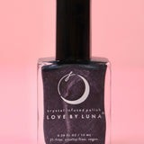 The Scorpio Zodiac Nail Polish with Micronized Obsidian on a pink background.