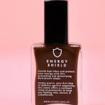 The Energy Shield Nail Polish with Micronized Smoky Quartz on a pink background.