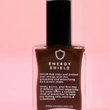 The Energy Shield Nail Polish with Micronized Smoky Quartz on a pink background.