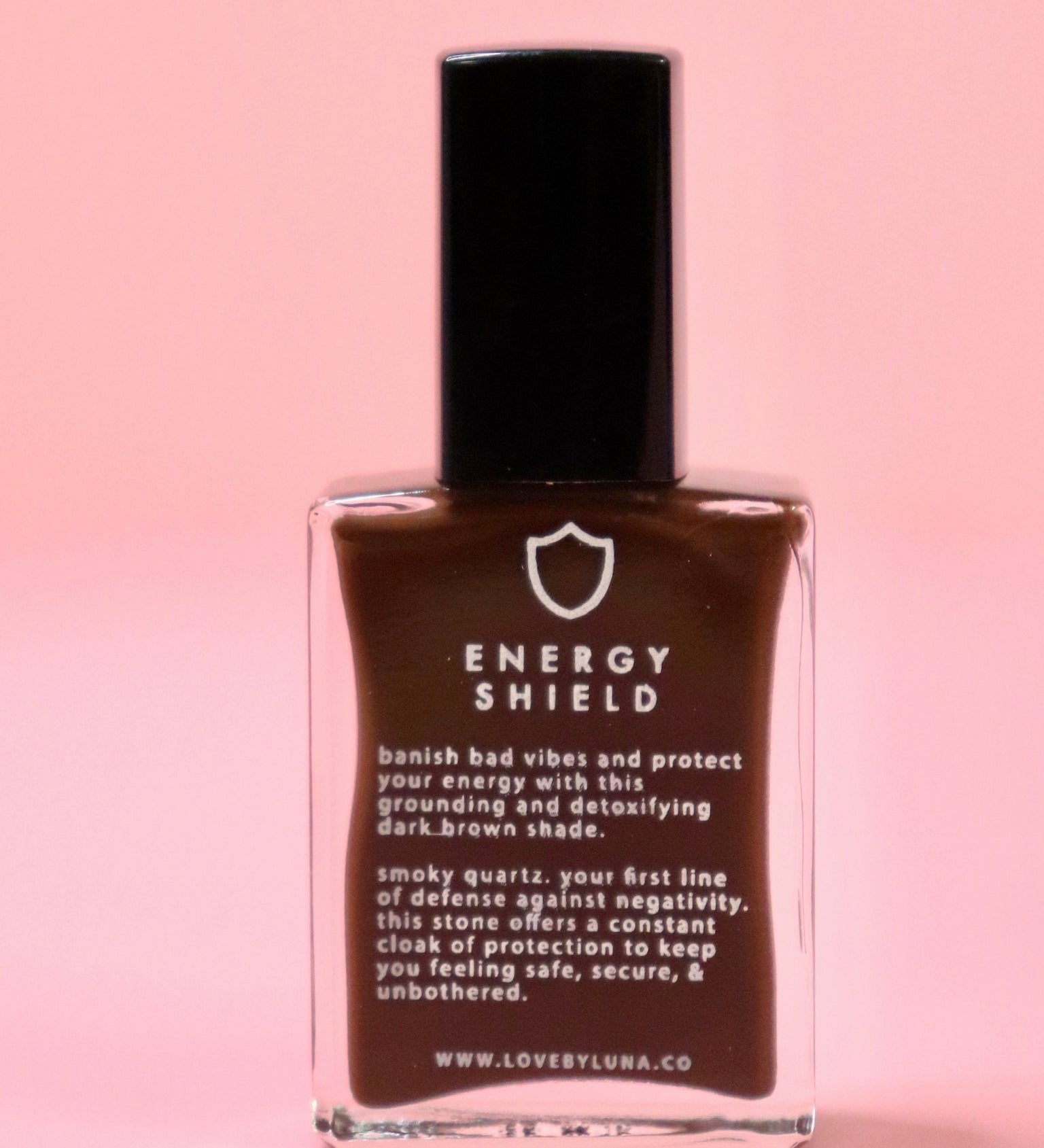 The Energy Shield Nail Polish with Micronized Smoky Quartz on a pink background.