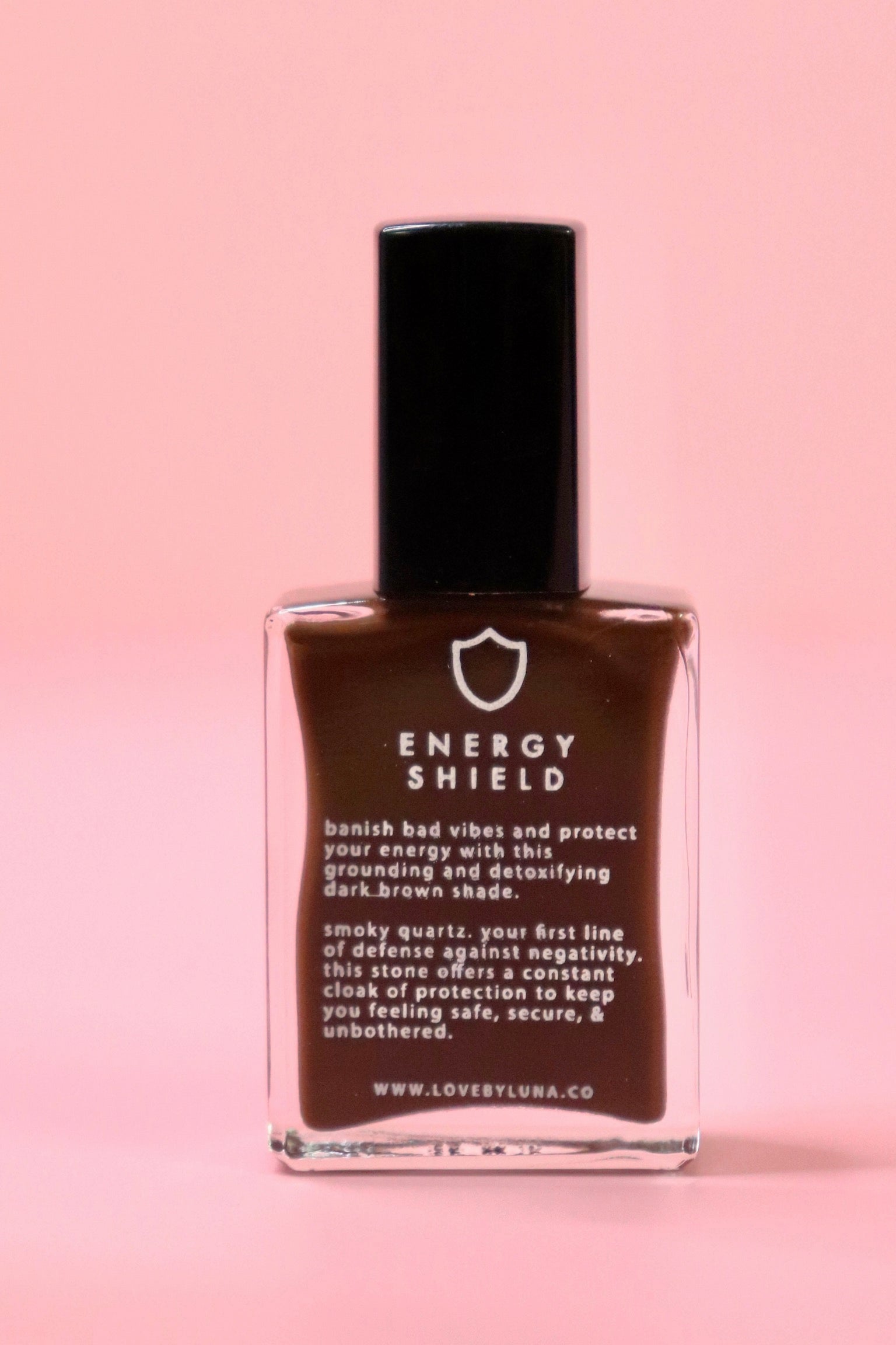 The Energy Shield Nail Polish with Micronized Smoky Quartz on a pink background.