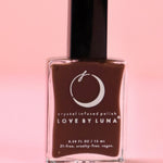 The Energy Shield Nail Polish with Micronized Smoky Quartz on a pink background.