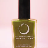 The Forest Retreat Nail Polish with Micronized Moss Agate on a pink background.