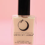 The Goddess Nail Polish with Micronized Rose Quartz, Selenite, & Moonstone on a pink background.