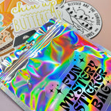 The Fun Mystery Sticker Bag on a pink background with stickers surrounding it.
